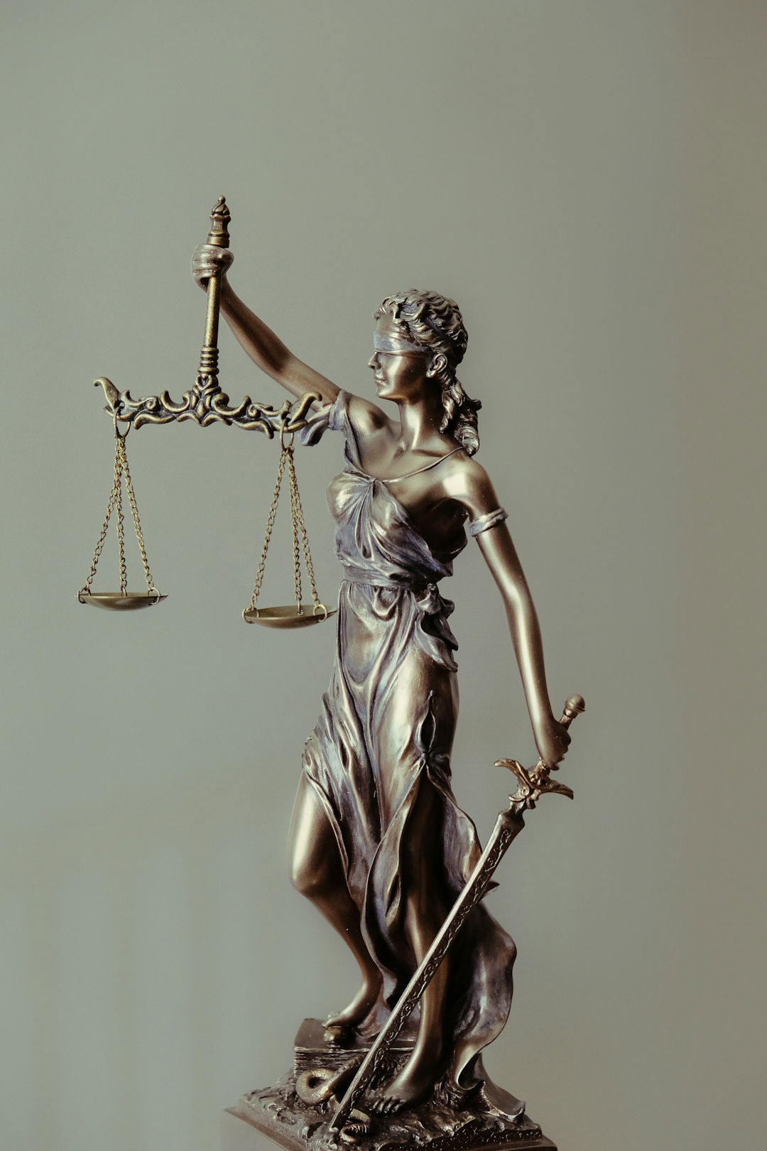 woman-in-gold-dress-holding-sword-figurine.jpg woman in gold dress holding sword figurine